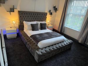 a bedroom with a large bed with a leather headboard at GS Maisons Hideaway in Sheffield