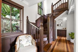 a living room with a staircase and a chair at Misty Valley Cottage in Mapleton