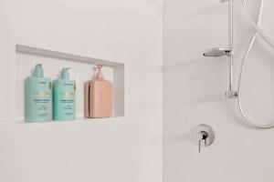 a shelf with three bottles of soap on it in a bathroom at Private Modern Bungalow - Separate Entry in Brisbane +11 photos