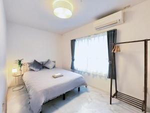 a bedroom with a white bed with a window at 幸 in Osaka