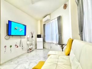 a living room with a white couch and a flat screen tv at 幸 in Osaka