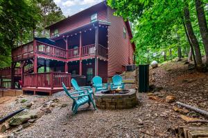 a large wooden house with blue chairs and a fire pit at Quiet mornings and golden hour views welcome to our woodland sanctuary Deer Watch Retreat in Ellijay