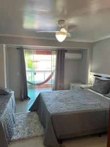 a bedroom with a bed and a ceiling fan at G2 Hospedagem Suites & Studio Praia Dos Anjos in Arraial do Cabo