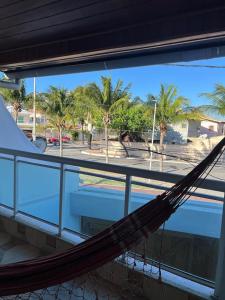 a hammock on top of a building with palm trees at G2 Hospedagem Suites & Studio Praia Dos Anjos in Arraial do Cabo