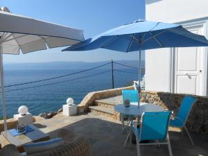 a patio with a table and chairs and an umbrella at HydraVista (Pearl) in Hydra