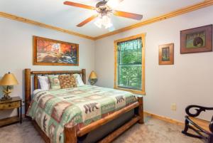 a bedroom with a bed and a ceiling fan at Quiet mornings and golden hour views welcome to our woodland sanctuary Deer Watch Retreat in Ellijay