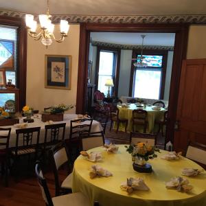 ein Esszimmer mit Tischen und Stühlen mit gelben Tischdecken in der Unterkunft L&N Bed and Breakfast Ltd in Henderson
