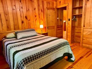 a bedroom with a bed in a wooden cabin at E-HOT SPRINGS MYSTIQUE - Historic Five Points Lake Hamilton in Hot Springs