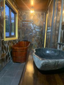 a large stone tub in a bathroom with a stone wall at Tam Coc Mountain Ecolodge in Ninh Binh