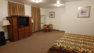a hotel room with a bed and a flat screen tv at Country Regency Inn & Suites in Manvel