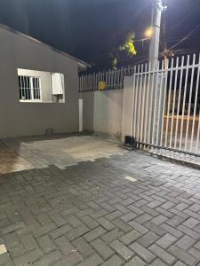 a house with a white fence and a patio at Casa Completa in Curitiba