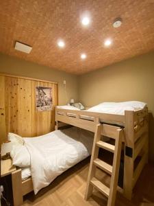 a bedroom with two bunk beds and a ladder at 姫路城下町 巡 in Himeji