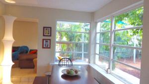 a living room with windows and a bowl of fruit on a table at Mermaid in Lake Worth