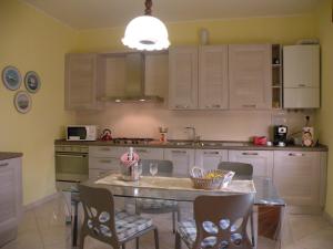 a kitchen with a table and chairs and a kitchen with white cabinets at Casa Oriana in Rosolina