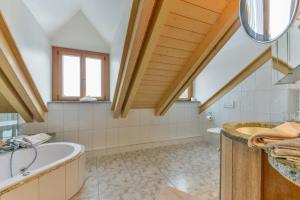ein Badezimmer mit einer großen Badewanne und einem Waschbecken in der Unterkunft Haus am Gries in Murnau am Staffelsee