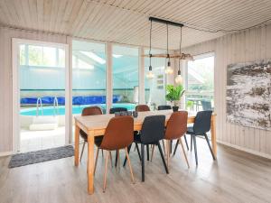 a dining room with a table and chairs and a pool at 4 star holiday home in Ørsted-By Traum in Ørsted