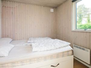 a bed in a small room with a window at 4 star holiday home in Ørsted-By Traum in Ørsted +28 photos