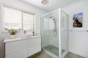 a white bathroom with a sink and a shower at Southcoast Haven in Shoalhaven Heads
