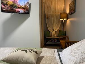 a bedroom with a bed with a pillow and a chair at L'isménia, Le Loft in Le Gosier