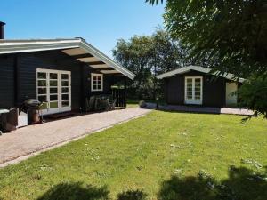 a small black house with a lawn in front of it at 4 star holiday home in Hemmet in Hemmet