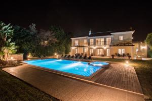 a swimming pool in front of a house at night at Villa Mar in Almancil