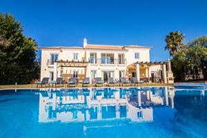 a villa with a swimming pool in front of a house at Villa Mar in Almancil