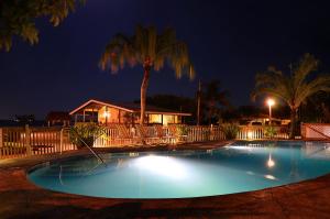 uma piscina à noite com uma casa e uma palmeira em Parmer's Resort em Little Torch Key
