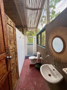 a bathroom with a toilet and a sink and a mirror at Intimunay Shala Yoga Center in Las Núñez