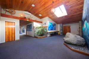 a living room with a wooden ceiling and a couch at Dusky Lodge in Kaikoura