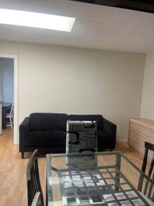 a living room with a black couch and a glass table at six bedroom house in Victoria