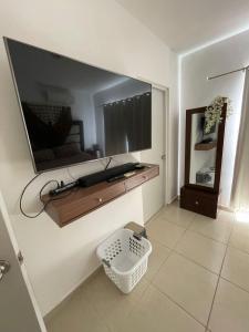a living room with a large flat screen tv on a wall at Casa del Conejo in Puerto Morelos