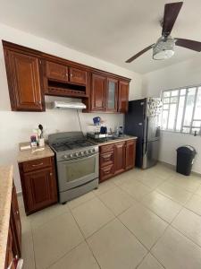a kitchen with wooden cabinets and a stainless steel refrigerator at Casa del Conejo in Puerto Morelos