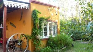 a yellow house with a window and a wheel at Casa de campo Miramar Norte in Miramar