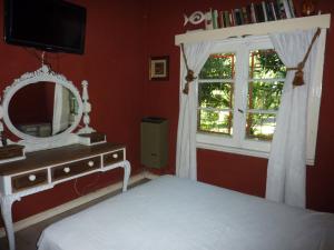 a bedroom with a mirror and a bed and a window at Casa de campo Miramar Norte in Miramar