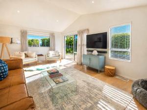 a living room with a couch and a tv at Oneroa Vines and Views- Stay Waiheke in Blackpool