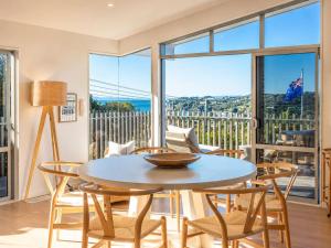 a dining room with a table and chairs and a large window at Oneroa Vines and Views- Stay Waiheke in Blackpool