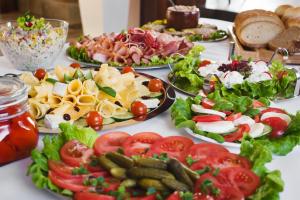 una mesa con muchos platos de comida. en Hotelik B&B Pod Dębami en Radwanice