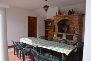 a dining room with a table and chairs and a fireplace at Vámosi Vendégház in Nemesvámos