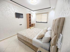 a bedroom with a bed and a tv on a wall at Ryad el houda in Agadir