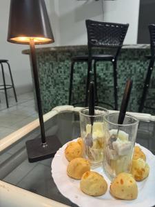 a plate of biscuits and two glasses of ice cream at Maia Hostel in Várzea Grande
