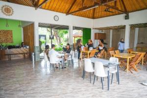 a group of people sitting at tables in a restaurant at Melati Kuta Lombok in Kuta Lombok