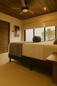 a bedroom with a large bed with a large window at La Cima Escondida Bijagua Rio Celeste 20 Min in Upala