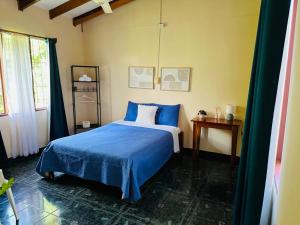 a bedroom with a blue bed and a window at Cabinas del Río in Upala +40 photos