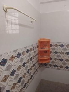a bathroom with tiles on the floor and a shelf at Pemmis living space in Bangalore +1 photo