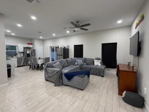 a living room with a gray couch and a kitchen at Room in Downtown Orlando! Close to everything! in Orlando