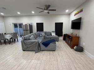 a living room with a gray couch and a tv at Room in Downtown Orlando! Close to everything! in Orlando