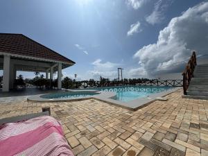 a swimming pool with a staircase and a blue sky at Alfa Boutique Hotel in Kiwengwa