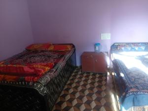 a room with two beds and a dresser in it at Anik home stay in Sari