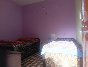 two beds in a room with purple walls at Anik home stay in Sari