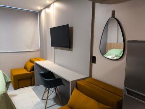a small room with a desk and a mirror at Flat 4 Mares - Refugio a dois - Com piscina e estacionamento em Intermares in Cabedelo